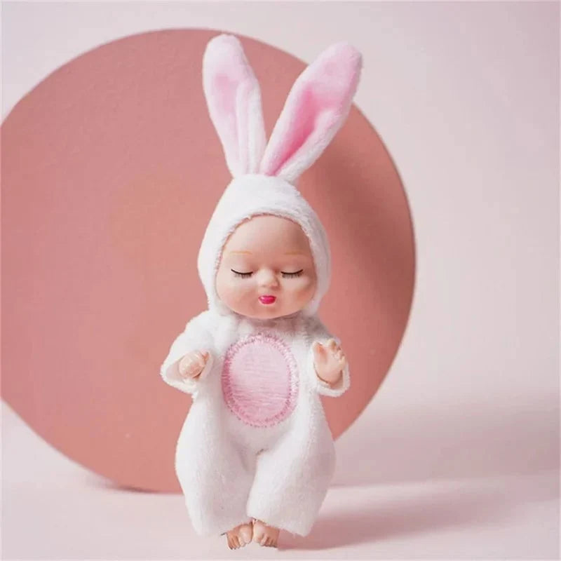 Mini sleeping baby doll wearing a soft white bunny costume